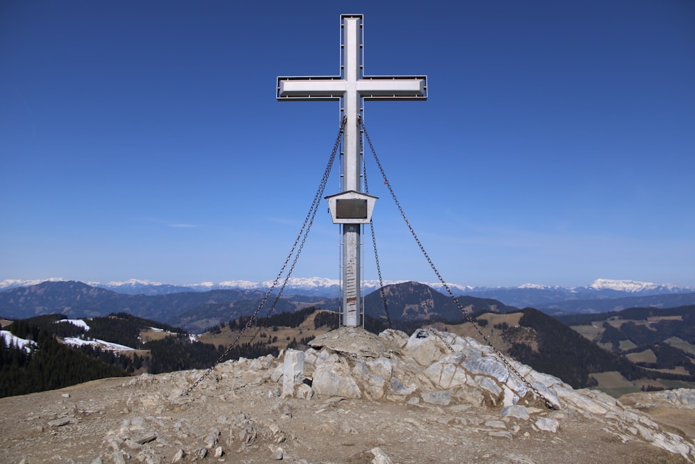 a cross on top of a mountain with mountains in the background