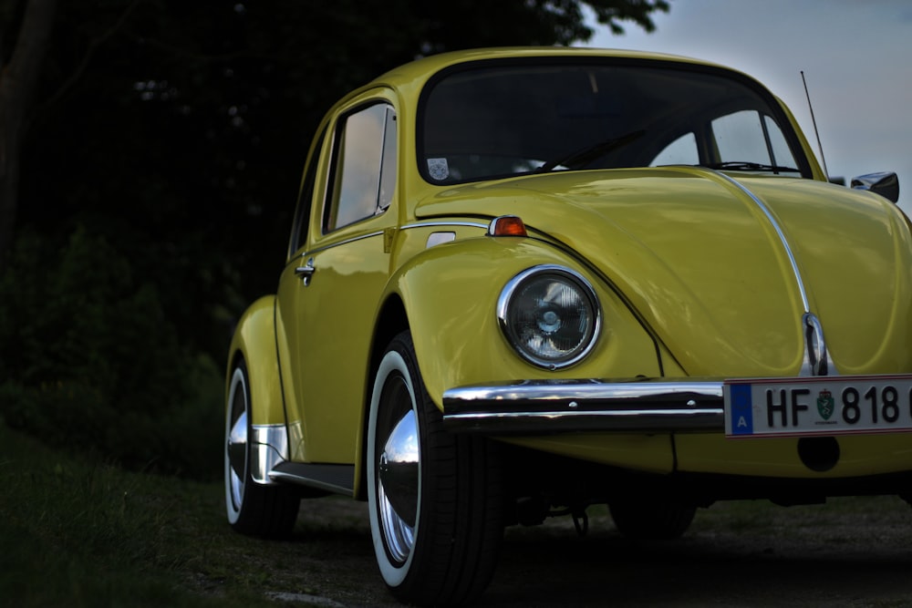 a yellow vw bug is parked on the side of the road