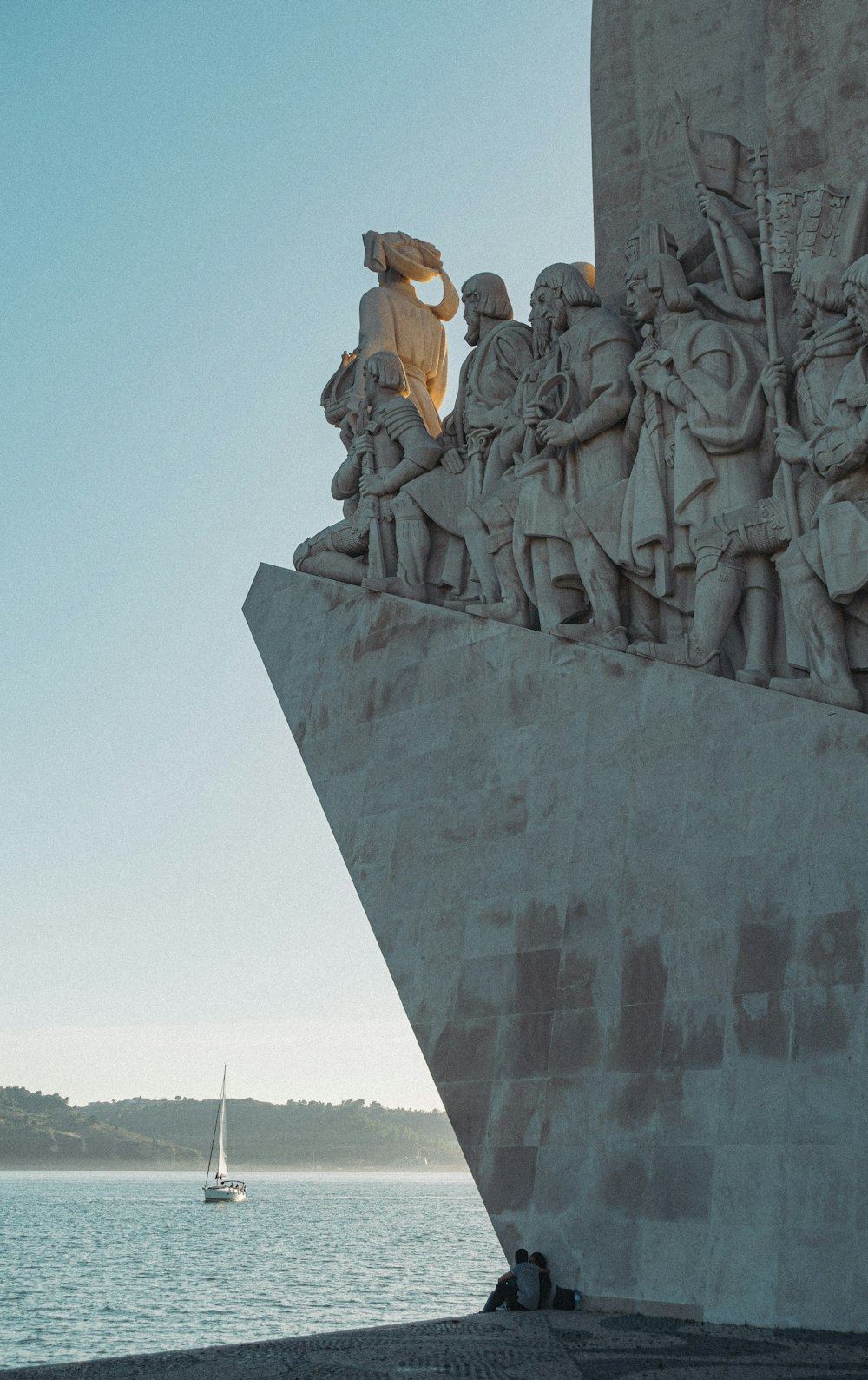 woman in white dress sitting on gray concrete statue