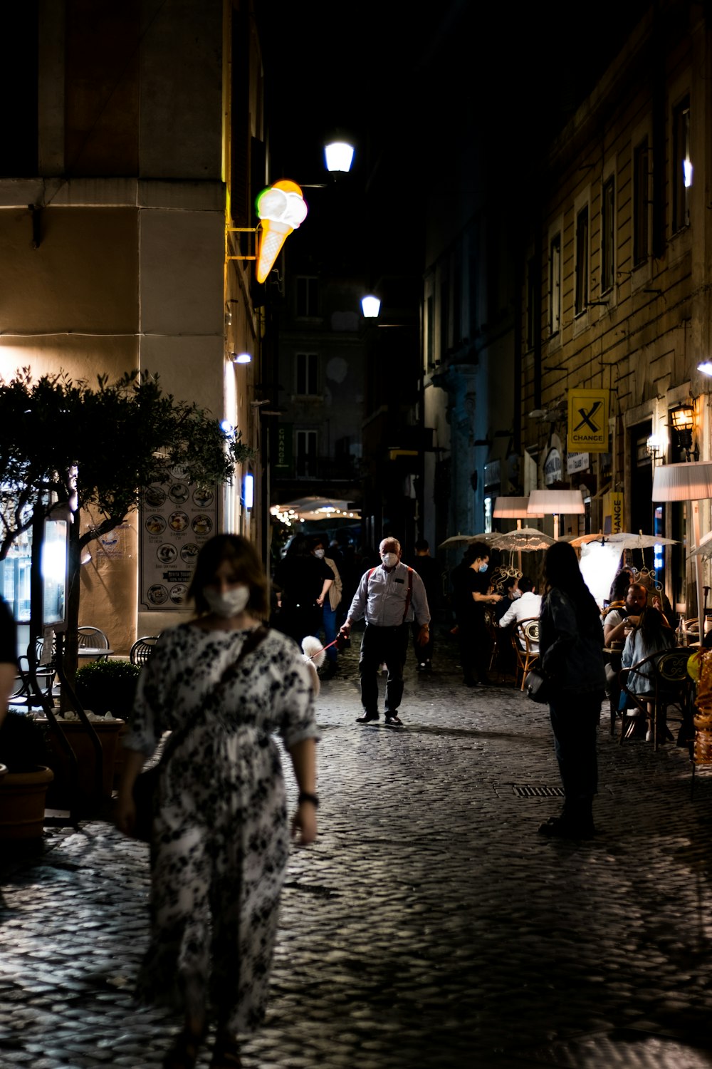 a group of people walking down a street at night