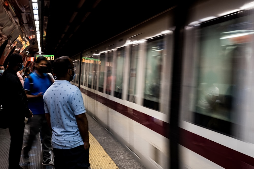 a group of people standing on a platform next to a train