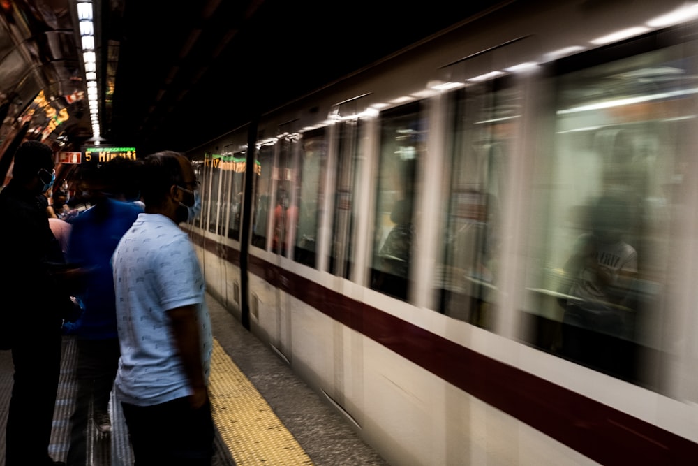 a group of people standing next to a train