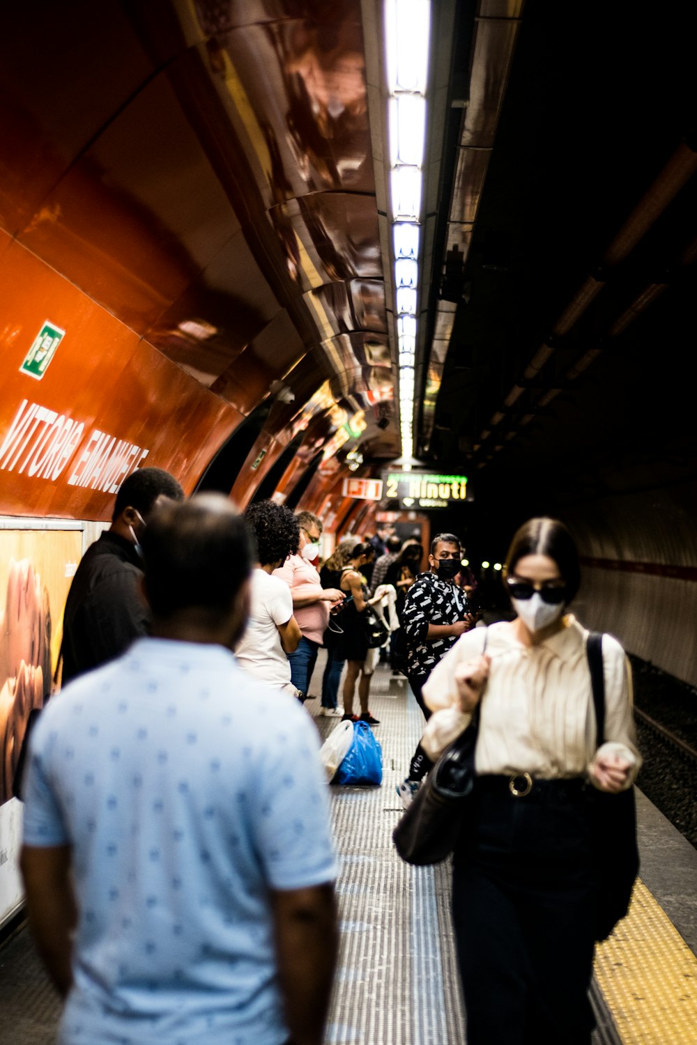 a group of people walking down a train platform