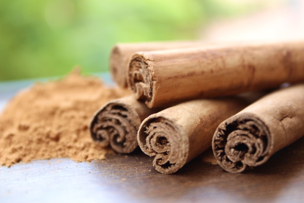 paus de canela e canela em pó em uma mesa