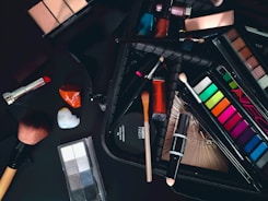a variety of cosmetics and makeup brushes on a table