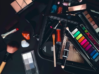 a variety of cosmetics and makeup brushes on a table