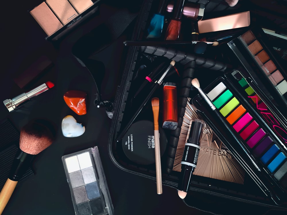 a variety of cosmetics and makeup brushes on a table