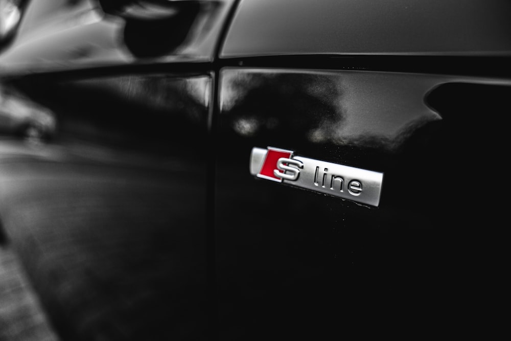 a close up of a black car with a red line sticker on it