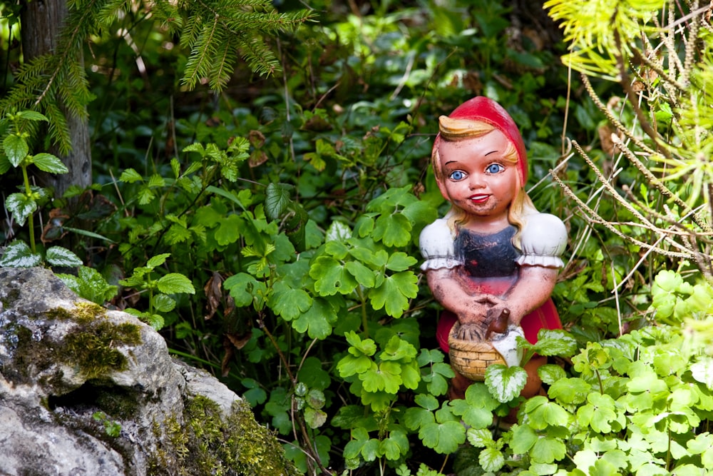 a statue of a little red riding on a horse in a forest