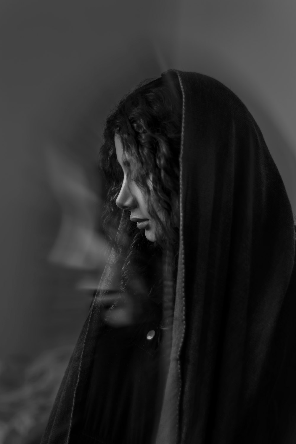 a black and white photo of a woman wearing a hood