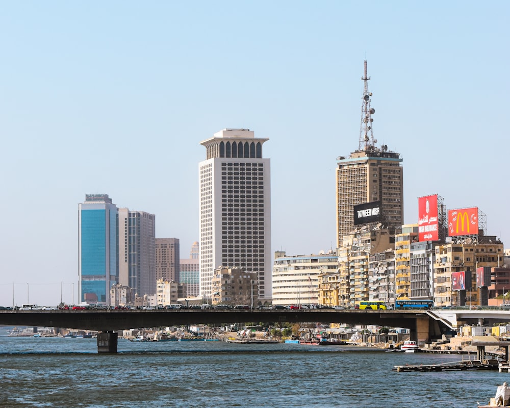 a bridge over a body of water with a city in the background