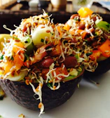 A vibrant salad with leafy greens, cherry tomatoes, and avocado slices.