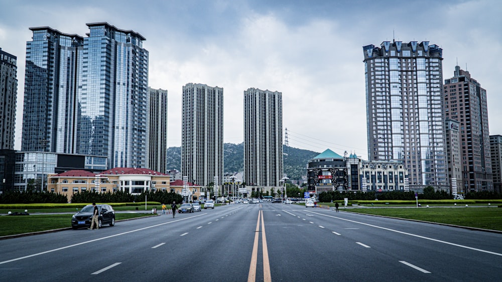 a city street with tall buildings in the background