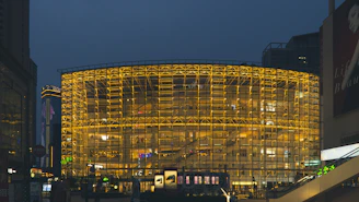 A sleek, modern commercial building with bustling retail shops and vibrant street activity under golden evening light.