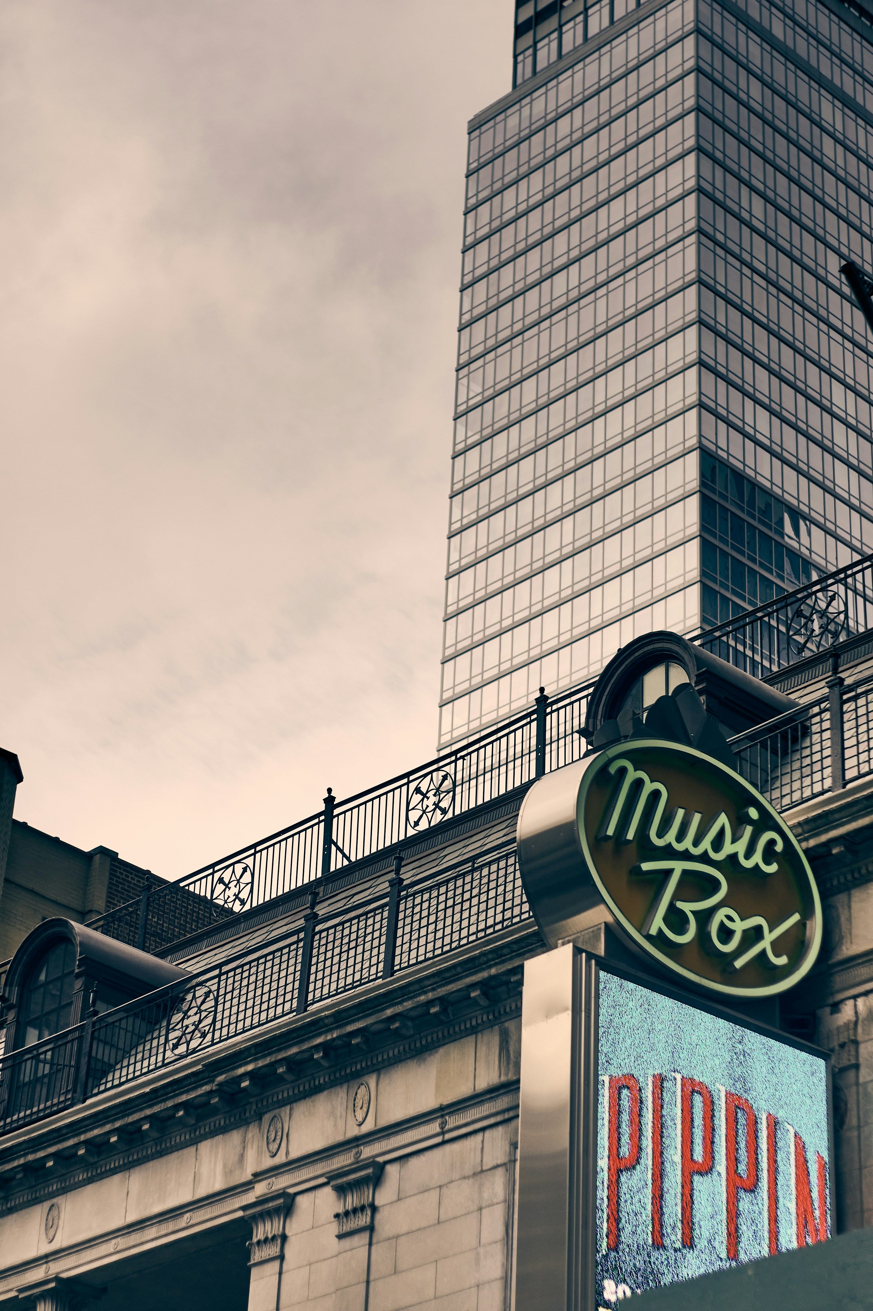 a sign for a musical box in front of a tall building