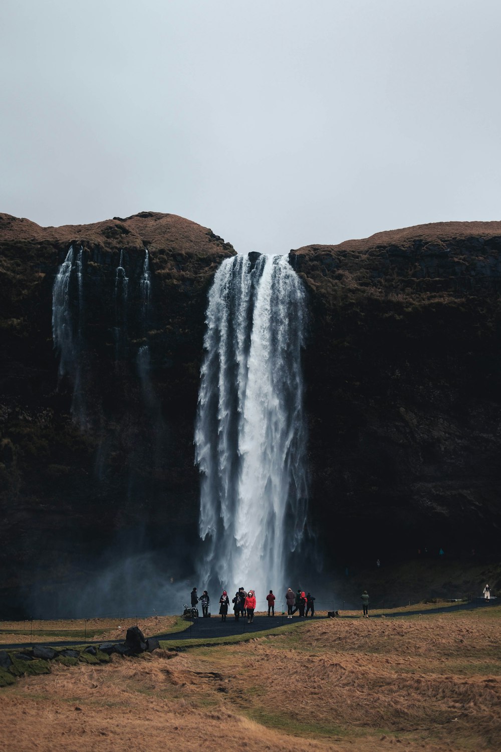 a group of people standing in front of a waterfall