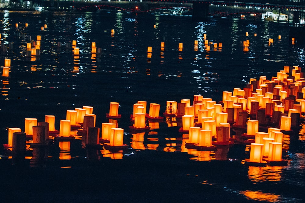 um grupo de velas flutuando em cima de um corpo de água