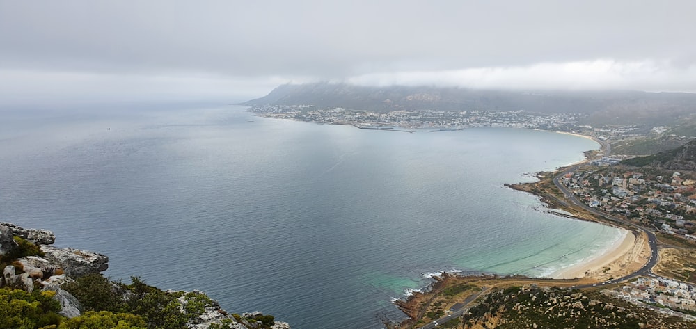 a large body of water sitting next to a lush green hillside