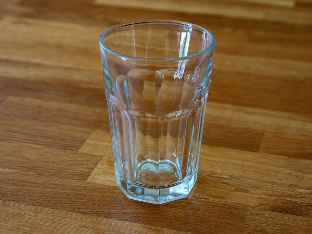a clear glass sitting on top of a wooden table