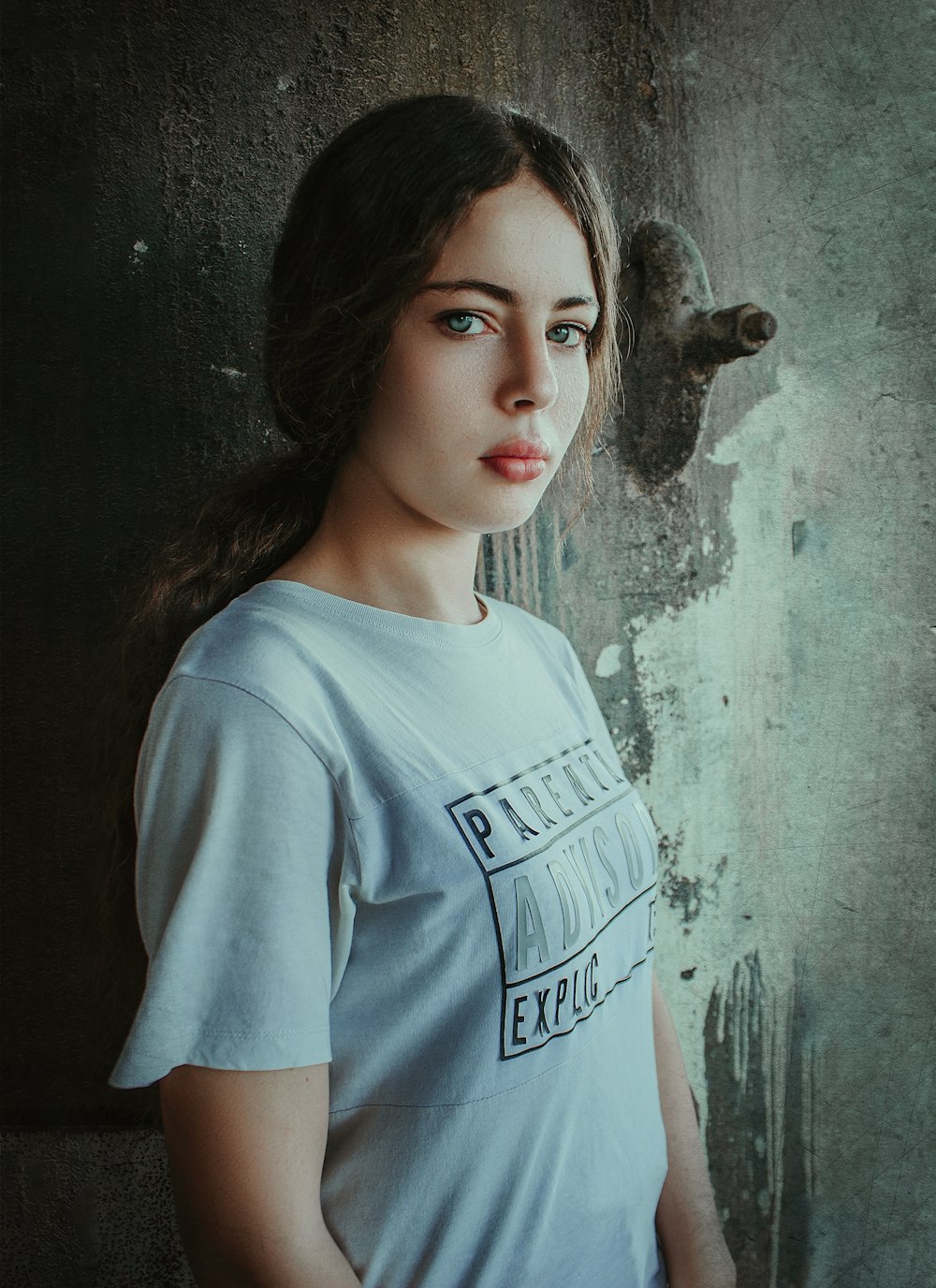 a woman standing in front of a grungy wall