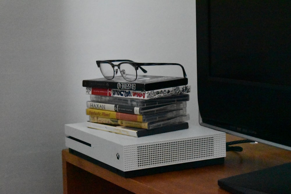 a stack of books with glasses on top of it