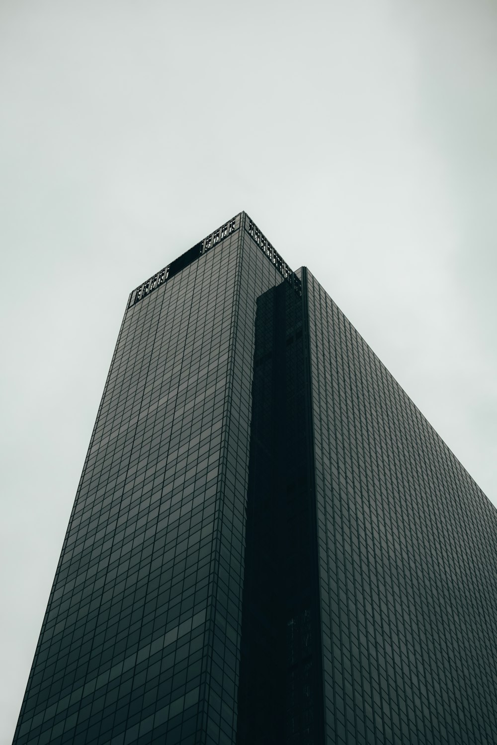 a very tall black building with a sky background