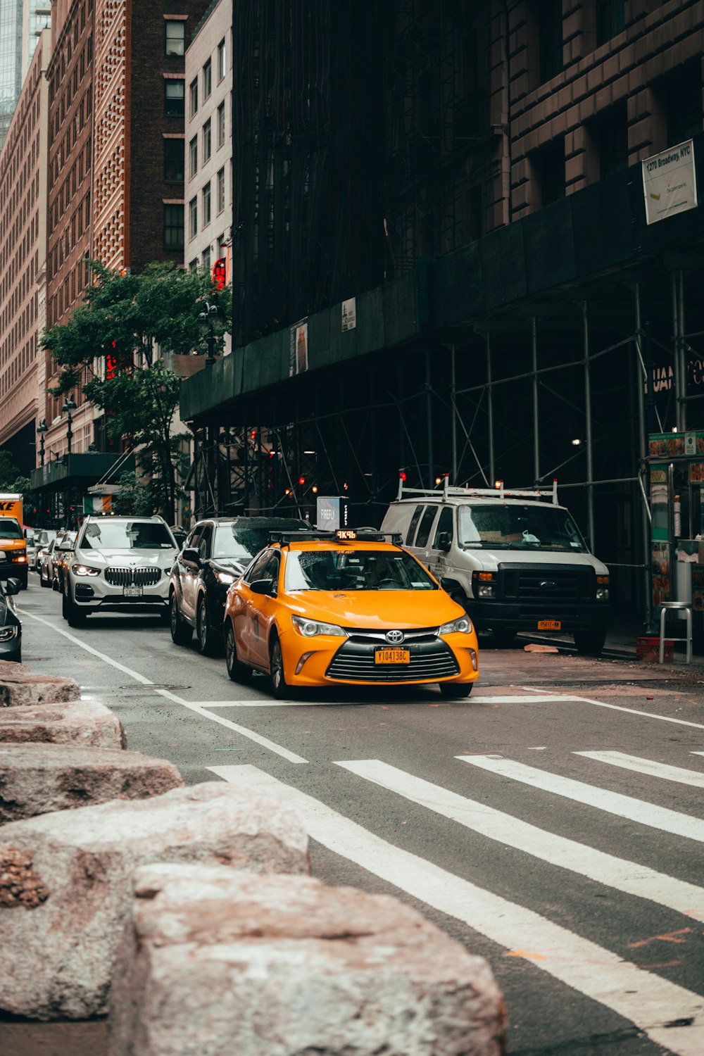 a city street filled with lots of traffic next to tall buildings