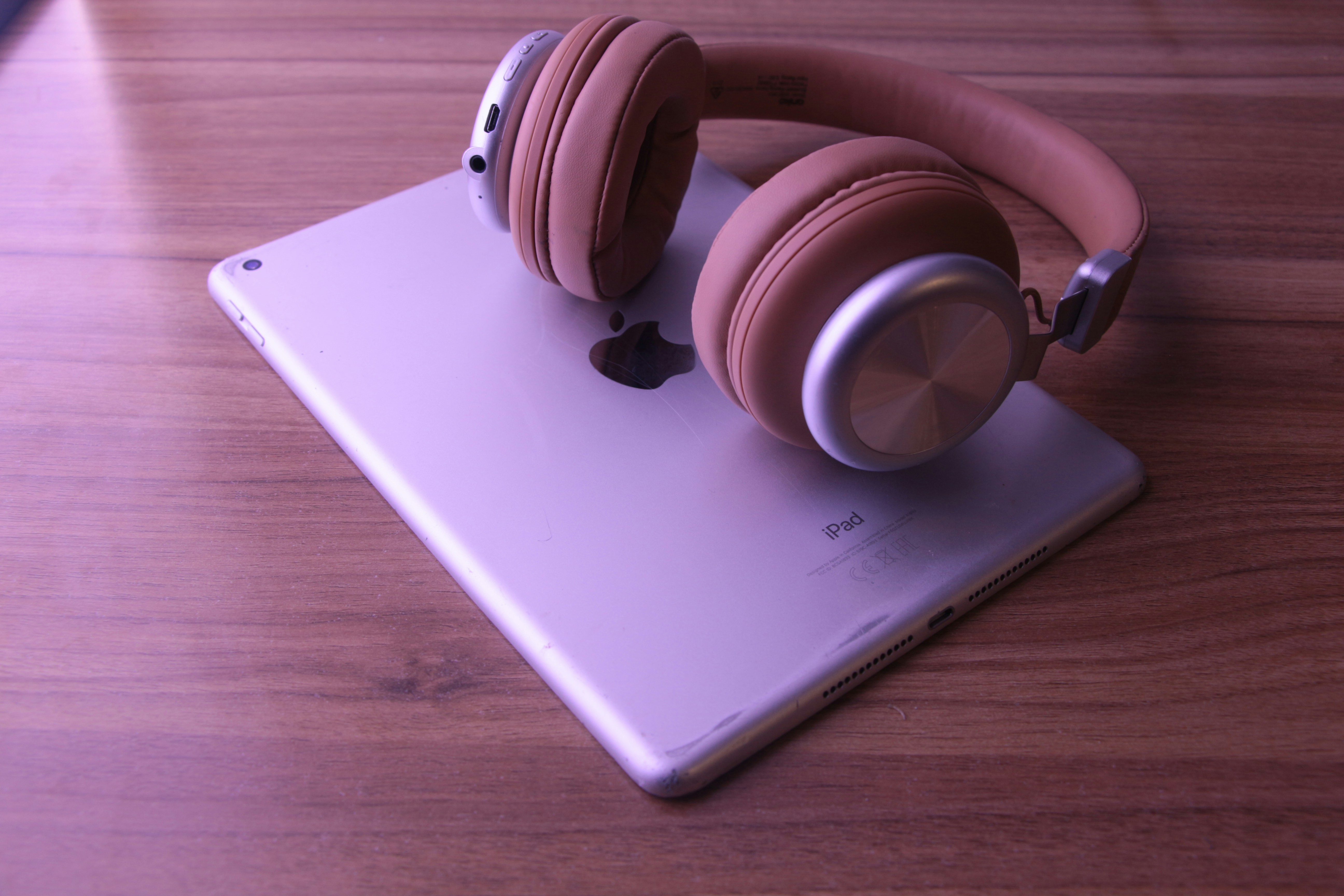 podcast headphones next to a tablet displaying mystery audio playlists