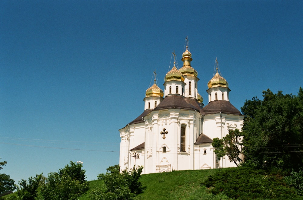 a white and gold church on top of a hill