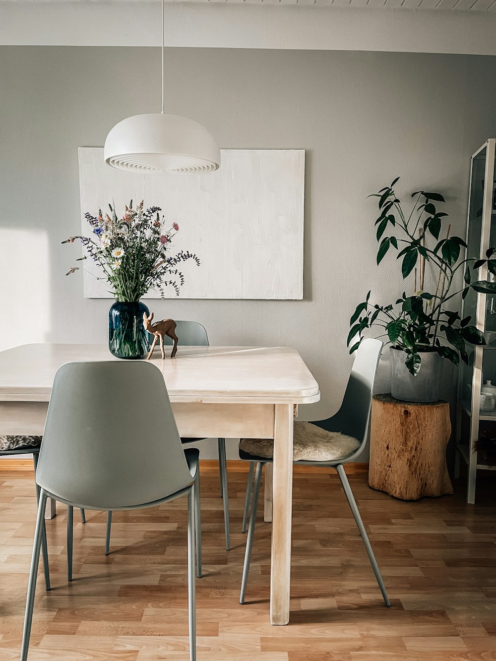 a dining room table with a vase of flowers on top of it