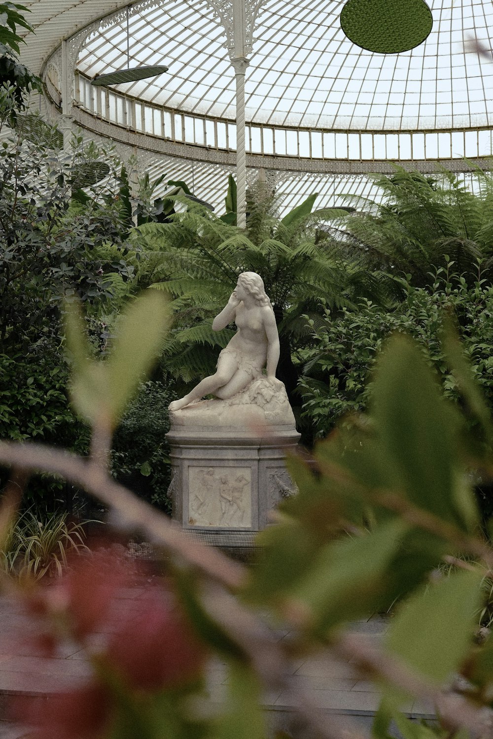 a statue of a woman in a greenhouse