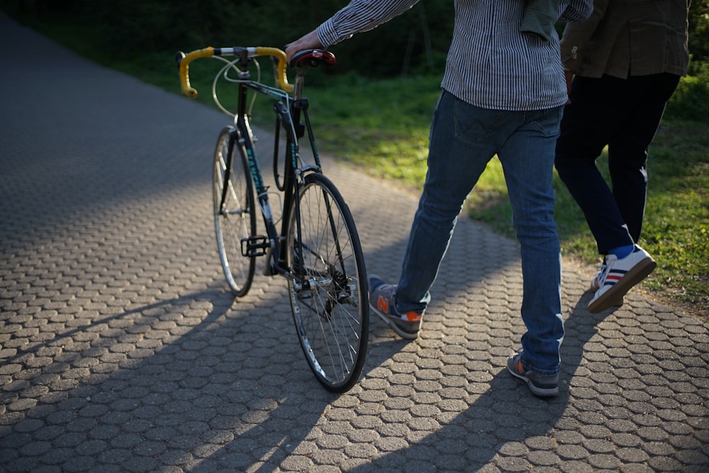 a man and a woman walking with a bike