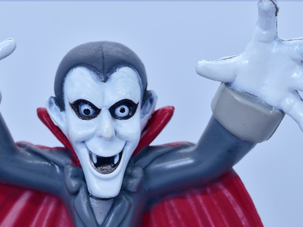 a close up of a toy figure wearing a red cape