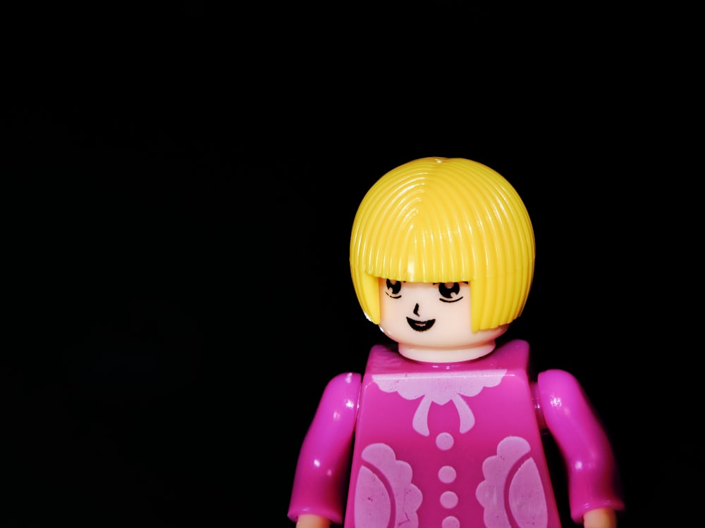 a close up of a lego figure wearing a pink dress