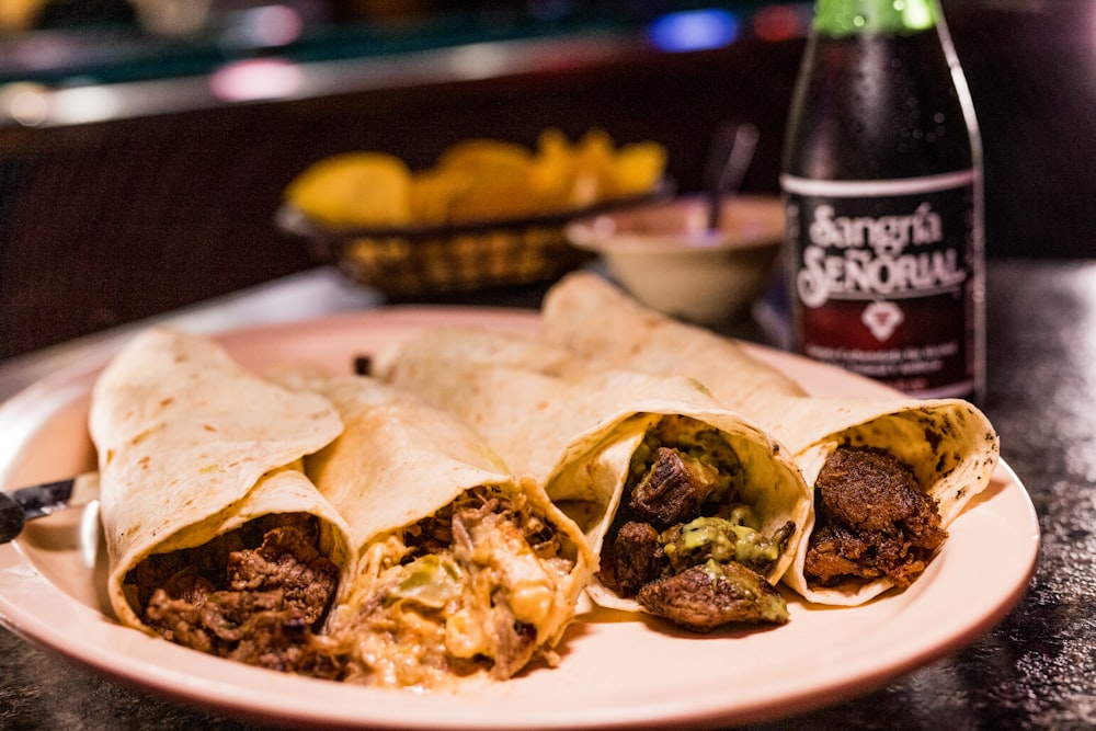 a plate of food and a bottle of beer on a table