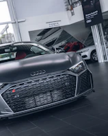 Luxurious Audi A6 displayed in a sophisticated dark environment with golden accents reflecting off its surface.