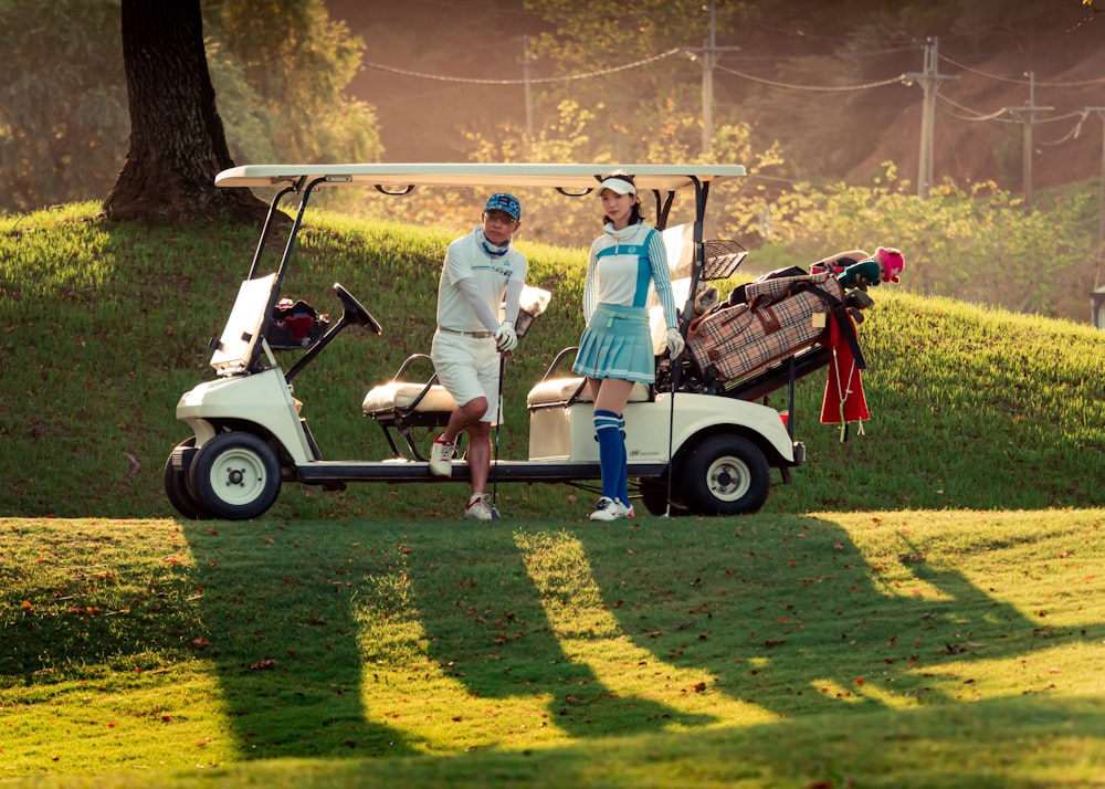 a man and a woman standing next to a golf cart