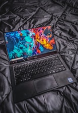 a laptop computer sitting on top of a bed
