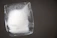 Close-up of a crystal-clear gourmet ice cube melting in a glass of sparkling water.