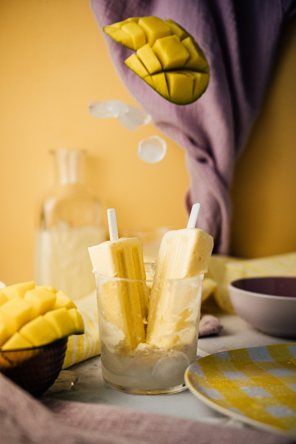 a table topped with a glass filled with bananas