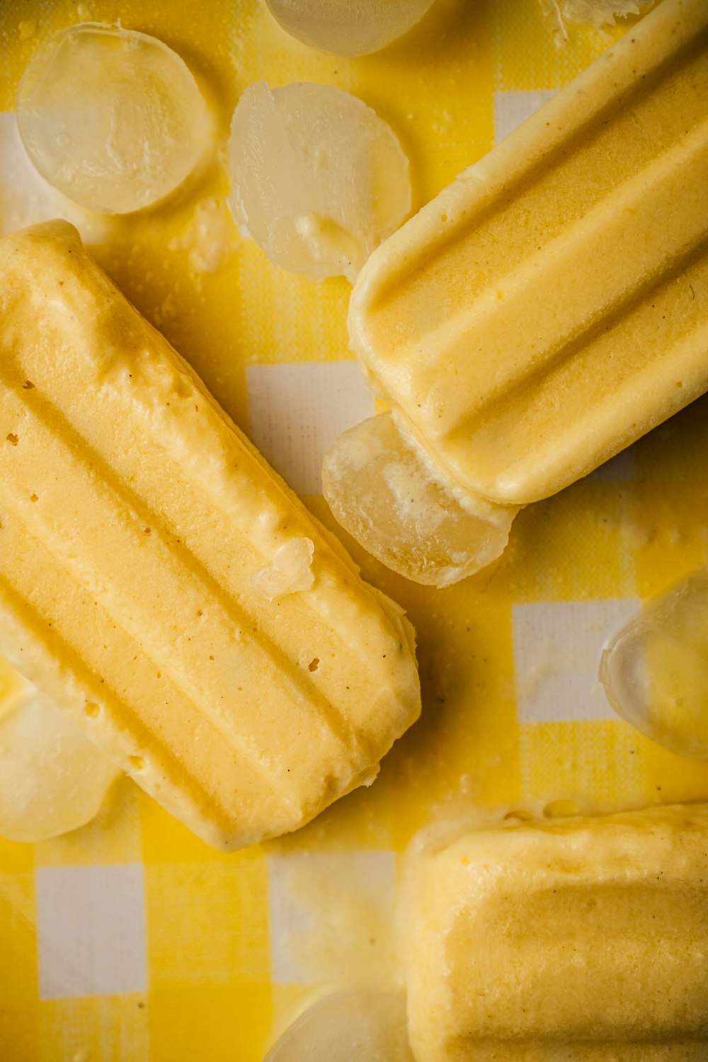 una tovaglia a scacchi gialli e bianchi con fette di gelato e limone