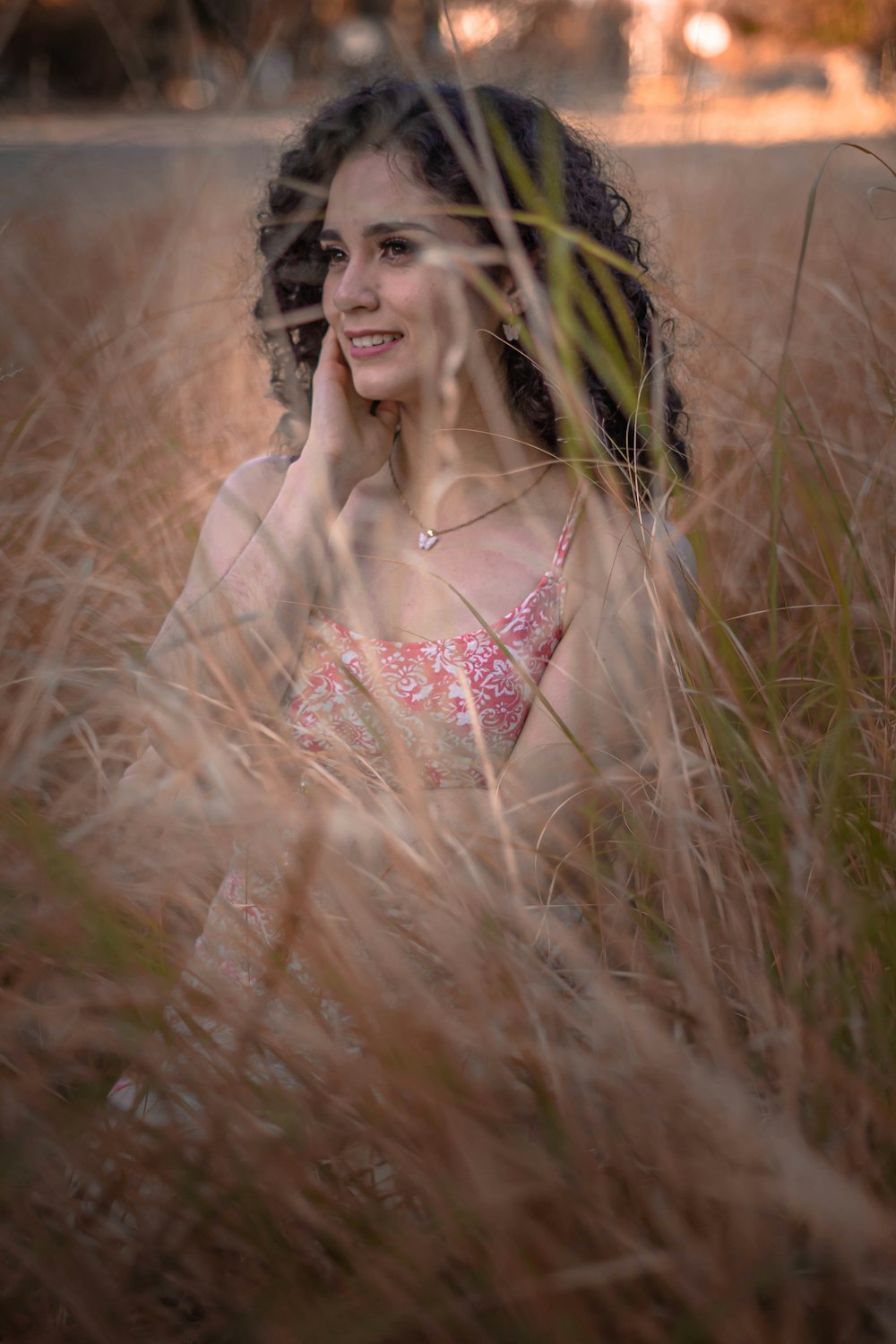 a woman sitting in a field of tall grass