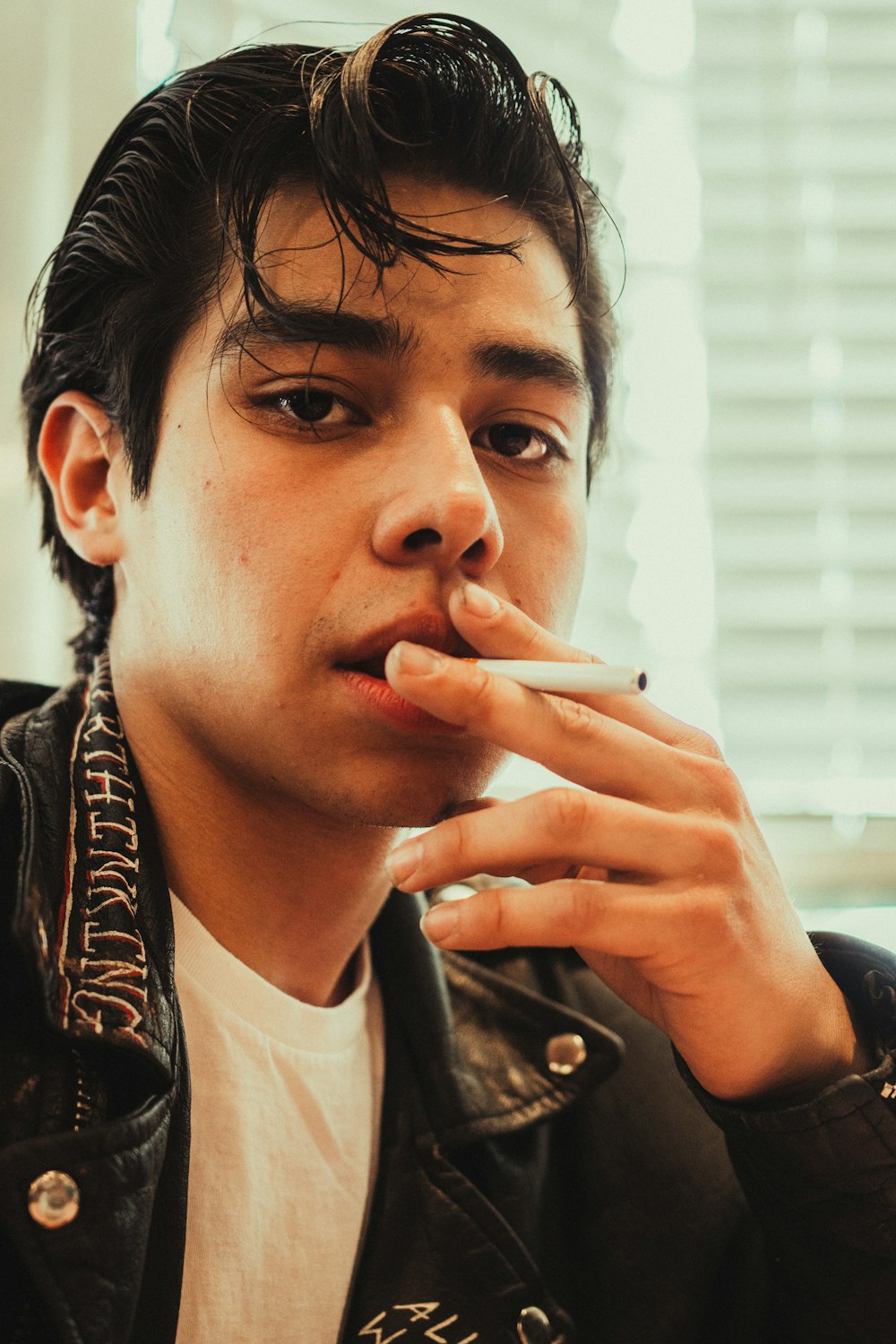 a young man smoking a cigarette in a room