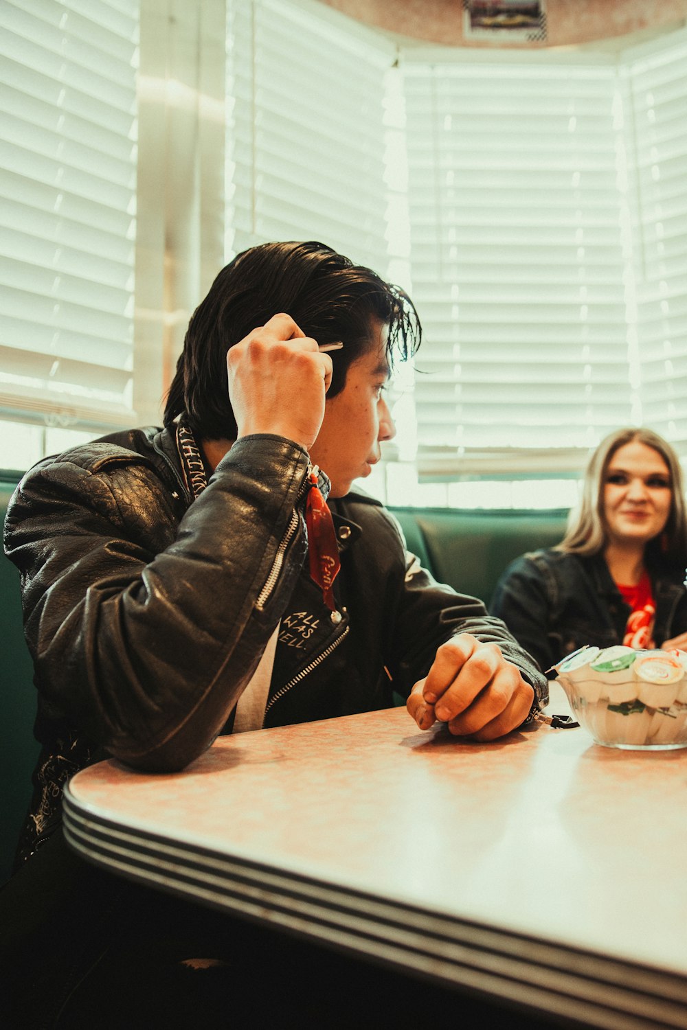 woman in black leather jacket sitting at the table