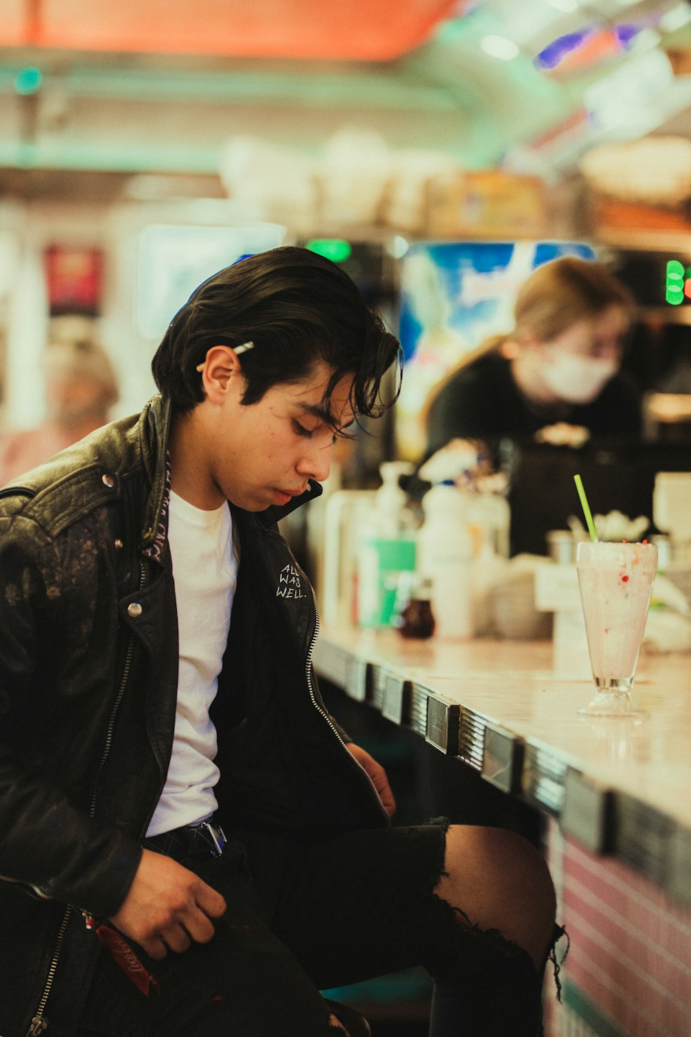 a man sitting at a table with a drink in front of him