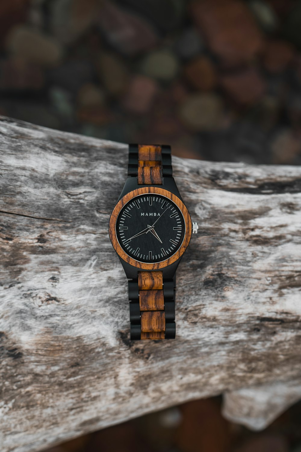 a wooden watch sitting on top of a piece of wood