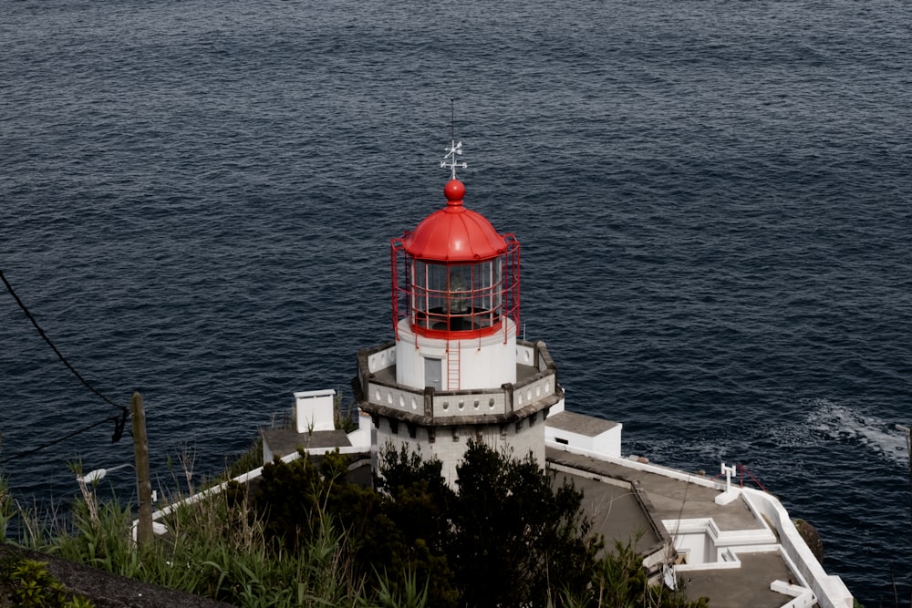 a red and white lighthouse sitting on top of a cliff