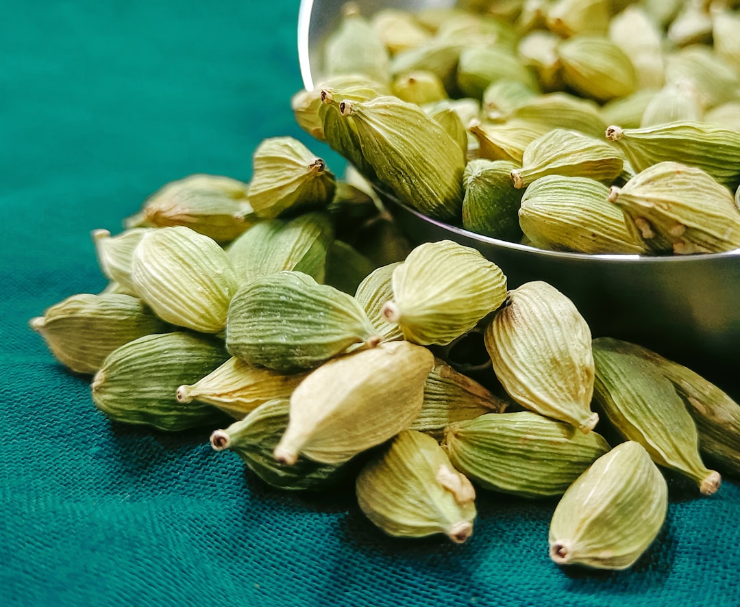 a metal bowl filled with green cardamoa seeds, A Bowl full of fresh green Cardamom