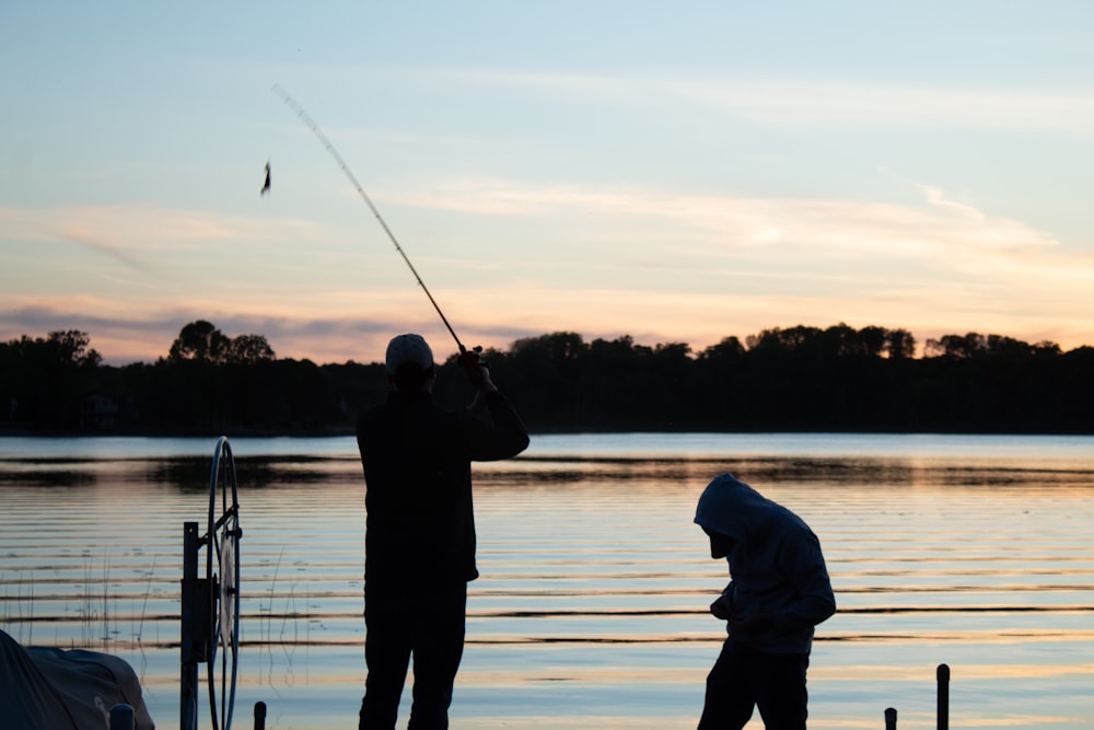 Zwei Männer beim Angeln auf einem See bei Sonnenuntergang