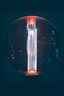 Modern LED bulb with a glowing hover effect illuminating a dark room with cool blue tones.